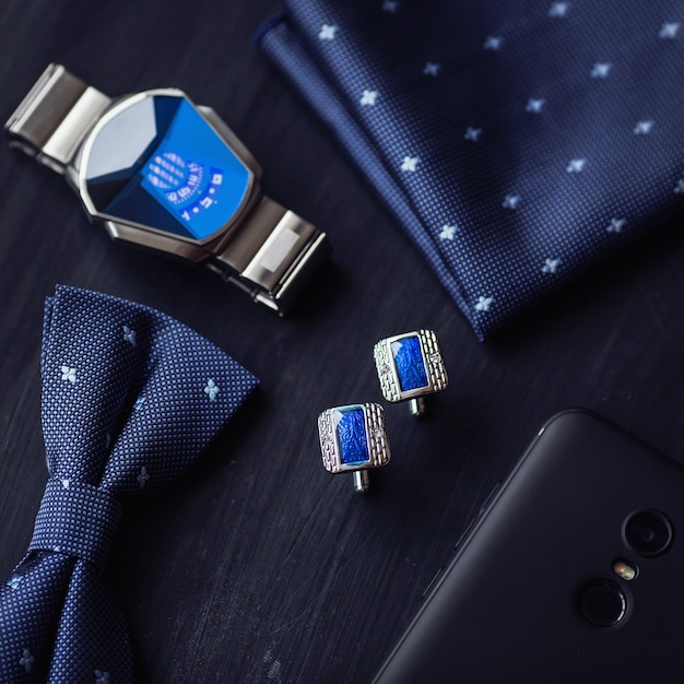 Bovenaanzicht van luxe mode mannen accessoires manchetknopen vlinder stijl horloge en smartphone