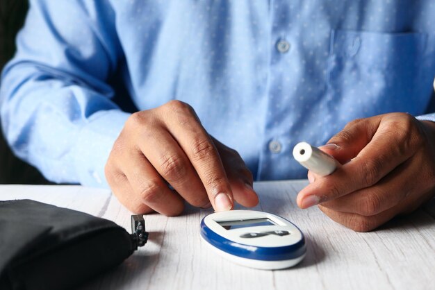 Foto bovenaanzicht van man hand diabetische meten op tafel