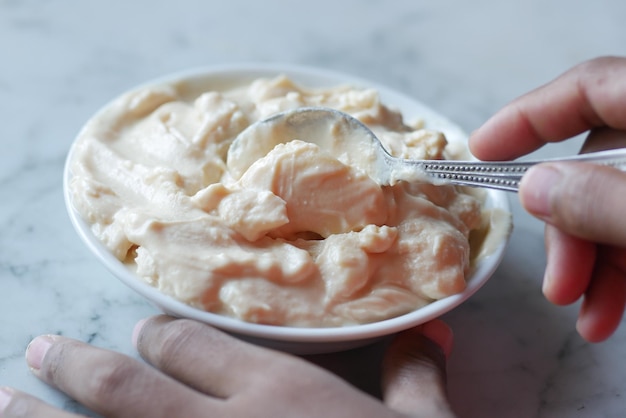 Bovenaanzicht van man39s hand die verse yoghurt uit een kom eet