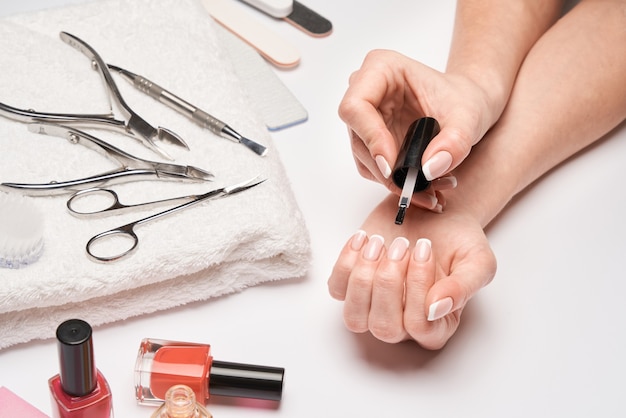 bovenaanzicht van manicure tools voor nagelverzorging op lichte ondergrond - borstel, schaar, nagellak, vijl en pincet