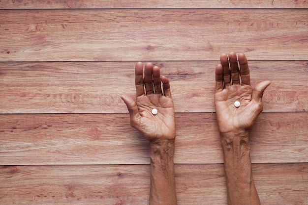 Foto bovenaanzicht van medische pillen op de palm van senior hand bovenaanzicht