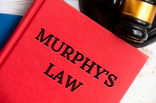 Bovenaanzicht van Murphy39s wetboek op houten tafel met hamer achtergrond