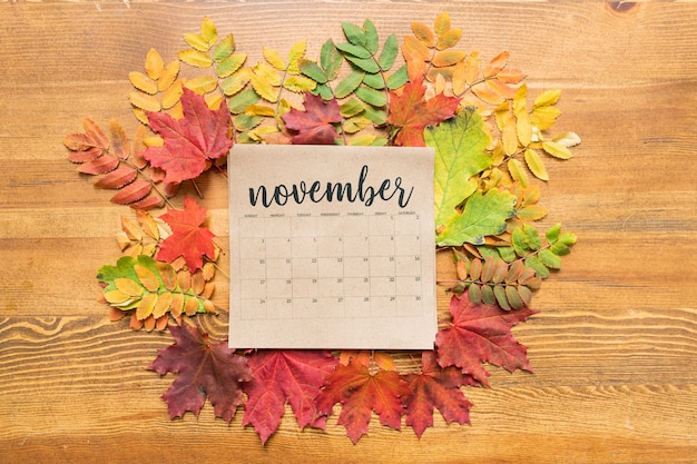 Bovenaanzicht van november kalenderblad omgeven door herfstbladeren van verschillende kleuren