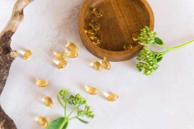 Bovenaanzicht van omega 3-olie of collageencapsules op houten schaal op tafel