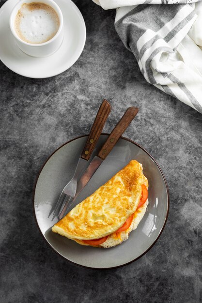 Bovenaanzicht van omelet met kaas en tomaten en een kopje koffie. Gezonde zelfgemaakte omelet voor het ontbijt.