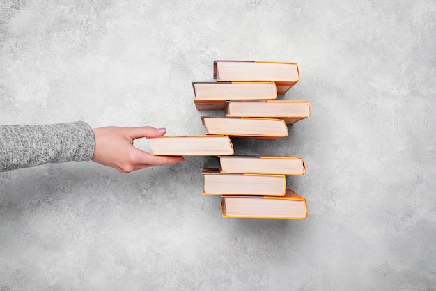 Bovenaanzicht van persoon stapel boeken met harde kaft