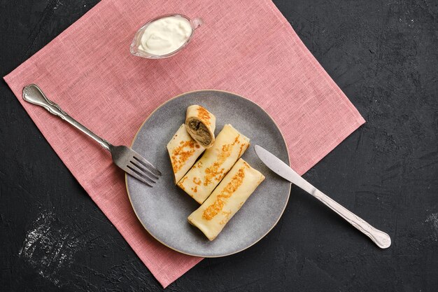 Bovenaanzicht van plaat met dunne pannenkoeken gevuld met bunny gehakt