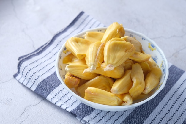 Bovenaanzicht van plakje jackfruit in een kom op tafel