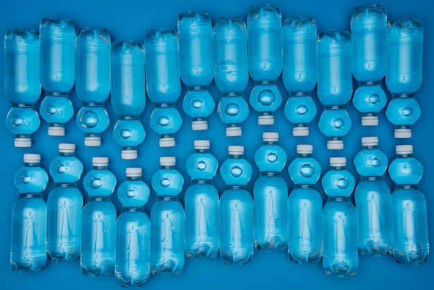 Bovenaanzicht van plastic waterflessen geïsoleerd op blauw