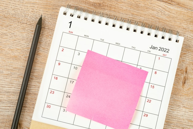 Bovenaanzicht van potlood, kalenderplanning en deadline met plaknotitie op houten achtergrond, kalenderbureau 2022 op januari-maand