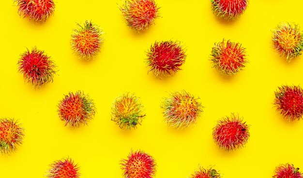 Bovenaanzicht van rambutan fruit op gele achtergrond. kopieer ruimte