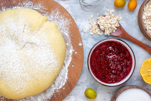 Bovenaanzicht van rauw gebak op ronde bord vers fruit havermout aardbeienjam op ijs achtergrond