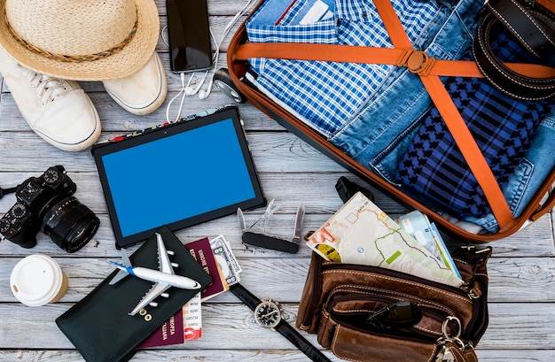 Bovenaanzicht van reisaccessoires, casual mannelijke kleding, bril paspoort portemonnee op houten achtergrond - vrijheid en vakantie concept