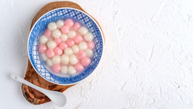 Bovenaanzicht van rode en witte tangyuan kleverig in blauwe kom