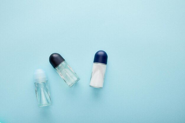 Bovenaanzicht van roll on flessen deodorant op blauwe achtergrond