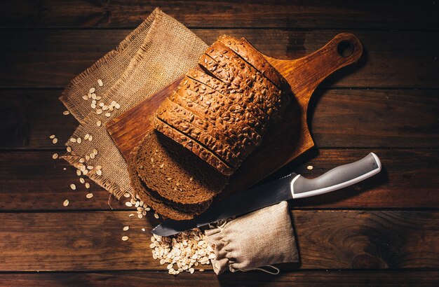 Bovenaanzicht van rustieke houten tafel met roggebrood en haver bovenop, rustieke stijl