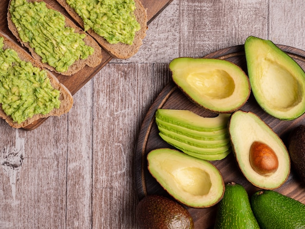 Bovenaanzicht van sandwiches gemaakt met avocado op een houten plank