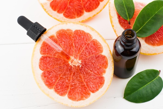 Bovenaanzicht van sappige grapefruit met grapefruit cosmetische oliepipet. verjongend serum.huidverzorging.