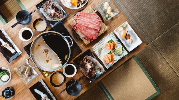 Bovenaanzicht van Shabu-set, inclusief zeldzame plakken Wagyu A5-rund, Shabu shoyu en heldere basis.