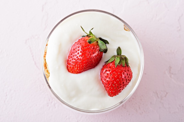 Bovenaanzicht van slagroom met aardbeien in glas.