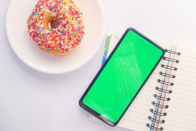 Bovenaanzicht van slimme telefoon en kladblok op tafel