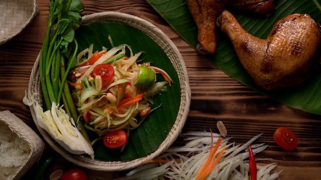 Bovenaanzicht van Somtum, Thais traditioneel eten met gegrilde kip, ingrediënten en plakkerige rijst