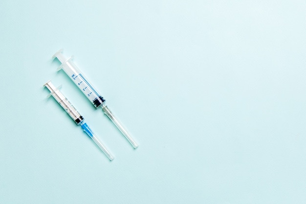 Bovenaanzicht van spuiten op een rij voor medische injectie op kleurrijke achtergrond met kopieerruimte. Gezondheid en vaccinatie concept.