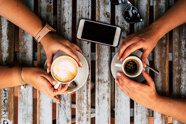 Bovenaanzicht van tafel met koffie en vrienden paar genieten van drankjes en pauze