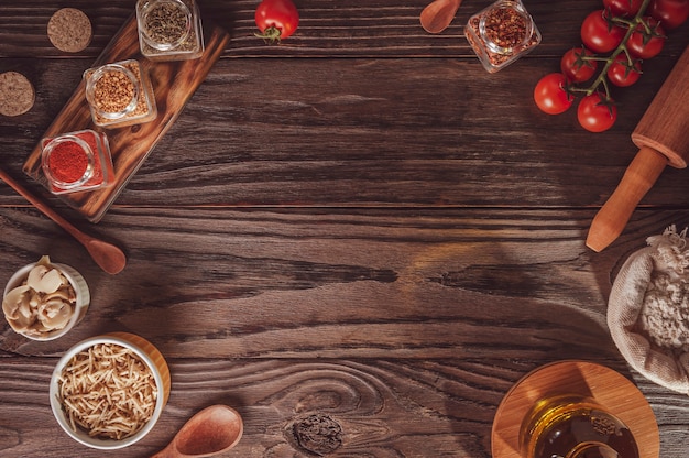 Bovenaanzicht van tafel met tomaat, champigons, aardappelsticks, ingrediënten en ruimte voor pizza-applicatie.