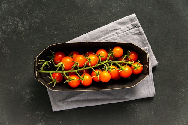 Bovenaanzicht van tak tomaten in papieren verpakking. Voedsel winkel levering concept