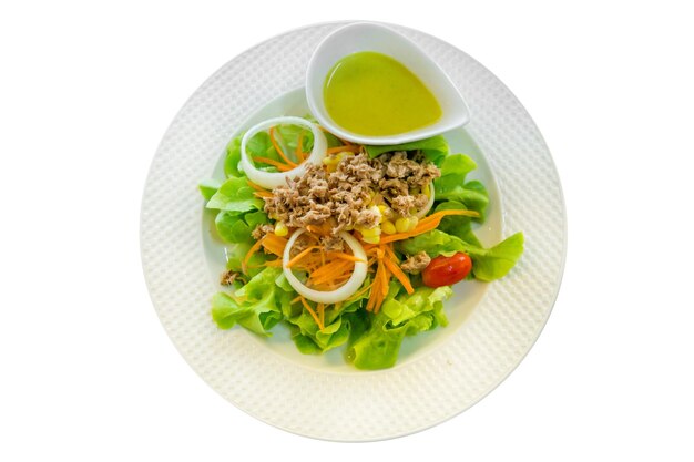 Bovenaanzicht van tonijnsalade met verse groente als slakomkommer tomaten witte ui salade op witte plaat focus selectief