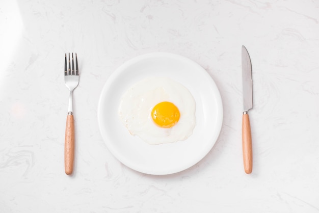 Bovenaanzicht van traditionele gezonde gemakkelijke snelle ontbijtmaaltijd gemaakt van gebakken eieren geserveerd op een bord.