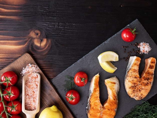 Bovenaanzicht van trays waarop zalm- en tomatenringen zijn gerangschikt. houten tafel