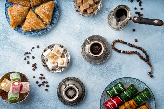 Bovenaanzicht van Turkse zoetigheden en Turkse koffie op lichtblauwe achtergrond