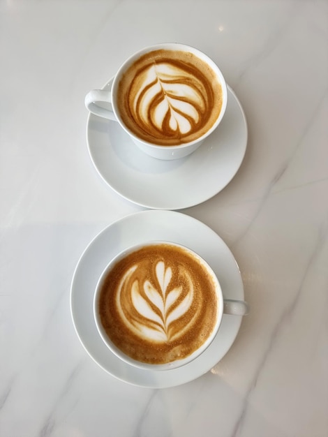 Bovenaanzicht van twee kopjes hete latte art tulpenkoffie