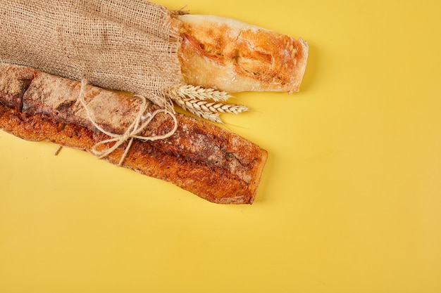 Bovenaanzicht van twee stokbroodbrood op een gele ondergrond