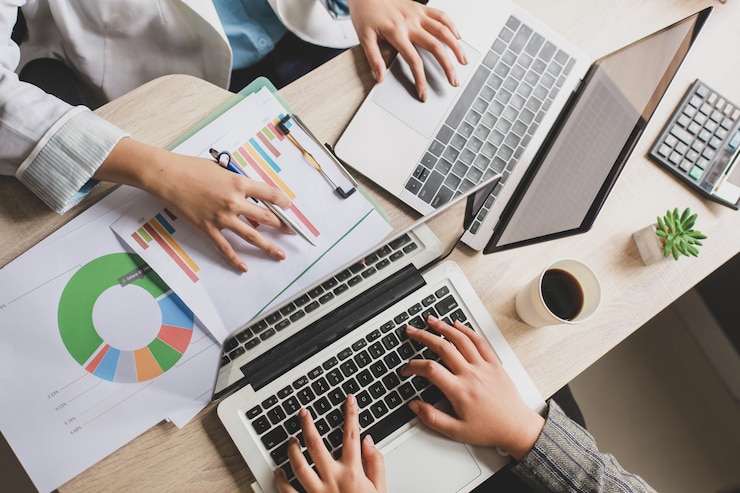 Foto bovenaanzicht van twee zakelijke vrouwen werken met laptop op bureau
