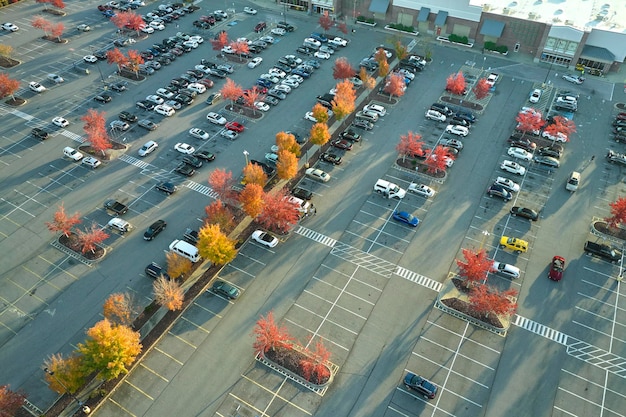 Bovenaanzicht van veel auto's geparkeerd op een parkeerplaats voor een strip mall plaza Concept van consumentisme en markteconomie