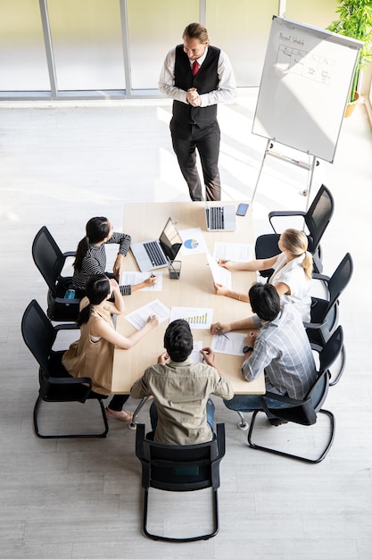 Bovenaanzicht van vergaderingen en consultaties van zakenmensen in de vergaderruimte van het bedrijf. Conferentie om de voortgang van de organisatie te analyseren en te vinden.