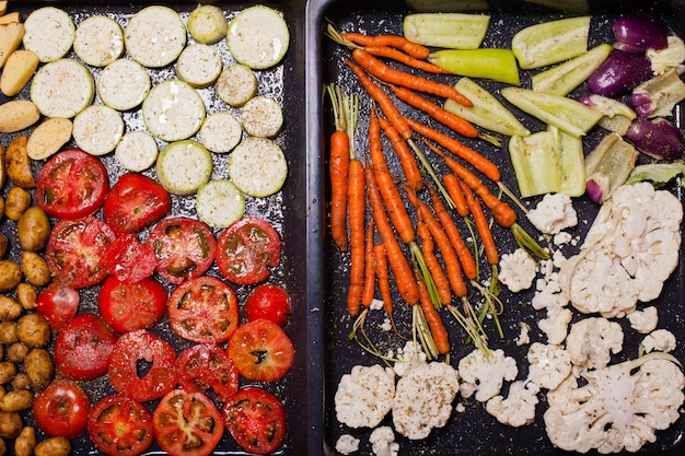 Foto bovenaanzicht van verschillende rauwe groenten voor het braden op de bakplaat. vegetarisch menuconcept