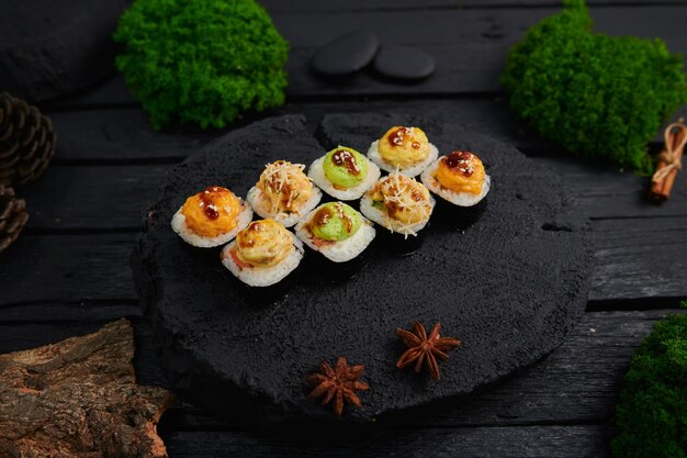 Bovenaanzicht van verschillende sushi en broodjes geplaatst op stenen bord Japans eten fest bovenaanzicht plat lag