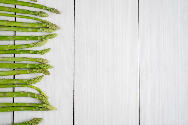 Foto bovenaanzicht van verse groene aspergeknoppen op de houten tafelachtergrond schot in de studio