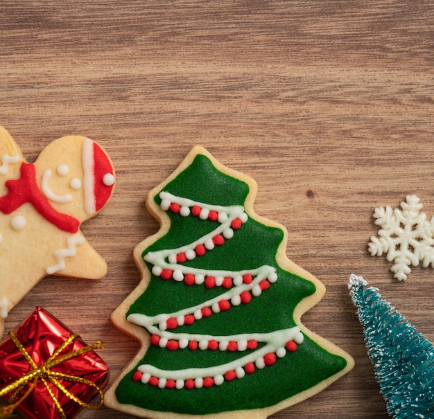 Bovenaanzicht van versierde peperkoek kerstkoekjes met versieringen op houten tafel achtergrond met kopie ruimte, concept van vakantieviering.