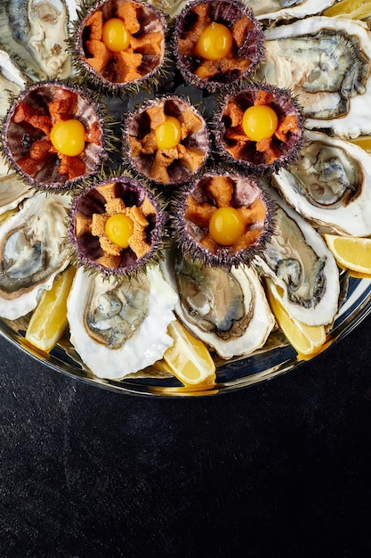 Bovenaanzicht van visschotel schaaldieren oesters zee-egels en balsamico saus