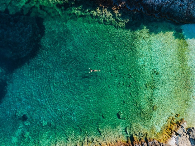 Bovenaanzicht van vrouw drijvend op de rug in helder zeewater Griekenland vakantie