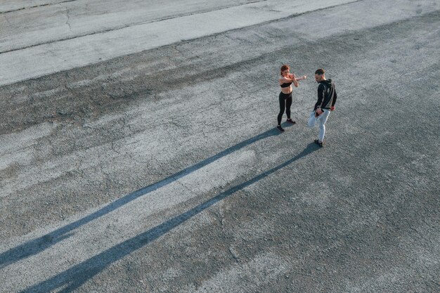 Bovenaanzicht van vrouw en man die 's avonds samen een fitnessdag op de weg hebben