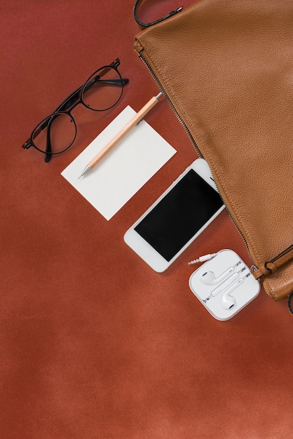 Bovenaanzicht van vrouw hipster reiziger dingen met telefoon, notitieblok, bril en oortelefoon