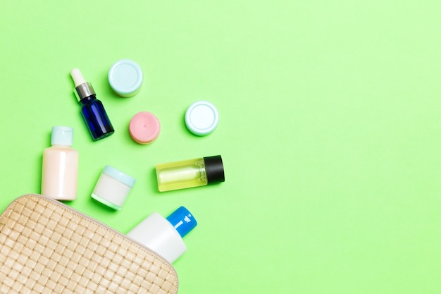 Bovenaanzicht van vrouwelijke cosmetica tas op groene achtergrond