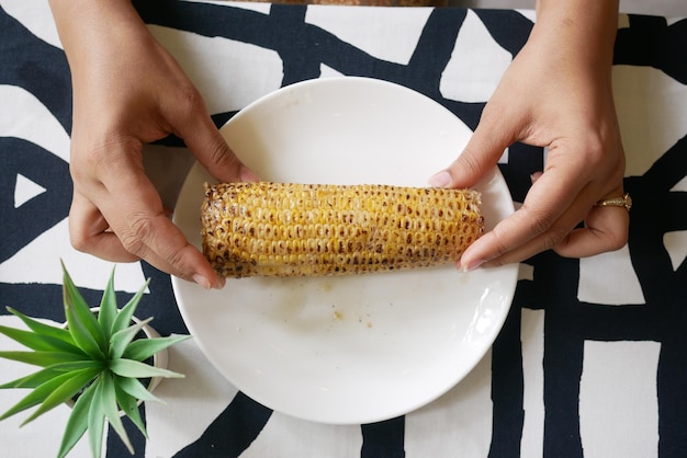 Bovenaanzicht van vrouwen hand met een zoete likdoorns in een kom op tafel