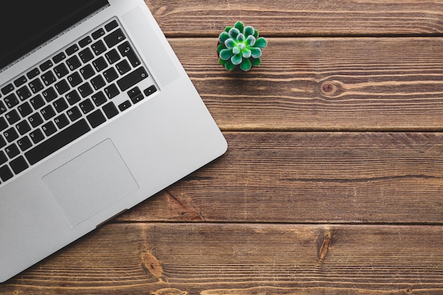 Bovenaanzicht van werkplek met laptop op houten tafel met kopieerruimte